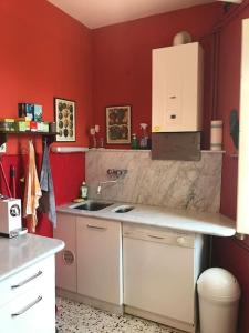 キャンニにあるCasa Kerni in der Toskanaの赤い壁のキッチン、シンク、カウンター