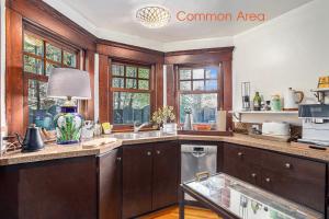 a kitchen with wooden cabinets and a sink and windows at Maple Family Suite in Berkeley