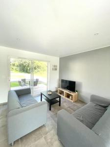 uma sala de estar com um sofá e uma televisão em Le Logis de Pomerol em Pomerol