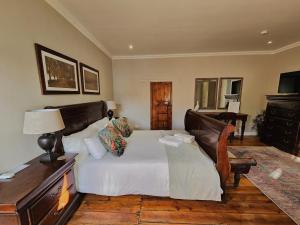 1 dormitorio con 1 cama y 1 mesa con lámpara en Adderley House Guest Accommodation, en Robertson