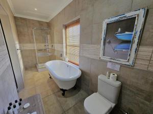 ein Badezimmer mit einem WC, einem Waschbecken und einer Badewanne in der Unterkunft Adderley House Guest Accommodation in Robertson