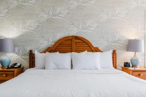 a bedroom with a white bed and a wall with leaves at The Geneva Inn in Lake Geneva