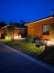 dom w nocy z oświetleniem na trawie w obiekcie Domki Letniskowe Jarek w Rowach