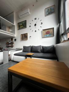 - un salon avec un canapé et un réveil sur le mur dans l'établissement 1 bedroom loft apartment, à Zlín