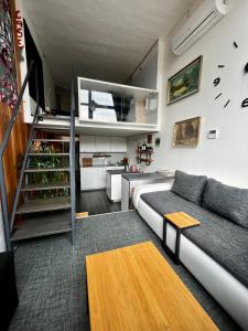 Il comprend un salon avec un canapé et une cuisine. dans l'établissement 1 bedroom loft apartment, à Zlín
