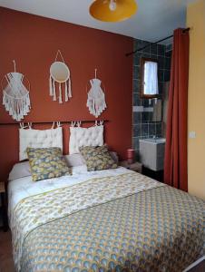 Schlafzimmer mit einem großen Bett mit roten Wänden in der Unterkunft Gites l’Olivier avec piscine in Vallon-Pont-dʼArc
