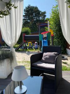 a patio with a couch and a playground at Domki Letniskowe Jarek in Rowy