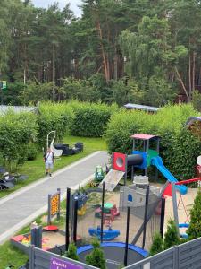 a child playing on a playground in a park at Domki Letniskowe Jarek in Rowy