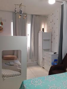 a small bedroom with a bed and a refrigerator at Cantinho acolhedor da Manu in Salvador