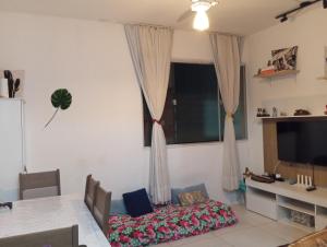 a living room with a table and a window at Cantinho acolhedor da Manu in Salvador