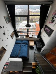 Habitación con cama y ventana grande. en 1 bedroom loft apartment en Zlín