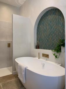 una vasca bianca in bagno con specchio di Home Chic Home - Les Suites de La Comédie a Montpellier