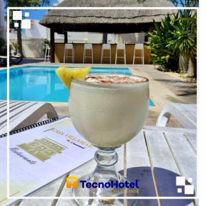 a drink sitting on a table next to a pool at Tecnohotel Casa Villamar in Progreso