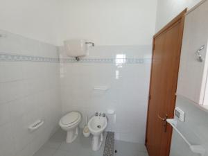 a white bathroom with a toilet and a bidet at Appartamento Loiacono - Seaview appartaments in Ricadi +33 photos