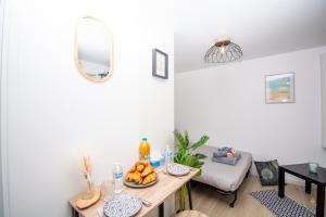 ein Wohnzimmer mit einem Tisch und einer Obstschale in der Unterkunft Studio rénové calme et cosy (10' Paris Pte d'Ivry) in Ivry-sur-Seine