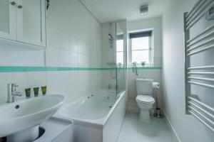 een witte badkamer met een wastafel en een toilet bij Towpath Gardens Apartment (Free Parking and Central) in Swindon