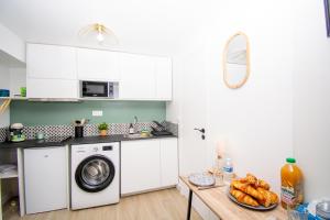 a kitchen with a washing machine and a table with bread at Studio rénové calme et cosy (10' Paris Pte d'Ivry) in Ivry-sur-Seine +10 photos