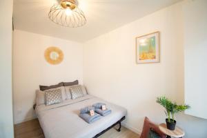 a bedroom with a bed with blue pillows on it at Studio rénové calme et cosy (10' Paris Pte d'Ivry) in Ivry-sur-Seine