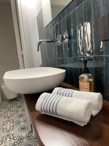 a bathroom with a sink and towels on a counter at Case Borgo vacanze Bouganville in Letojanni