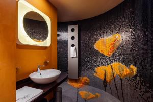 a bathroom with a sink and a mosaic wall at Les Fleurs Boutique Hotel in Sofia