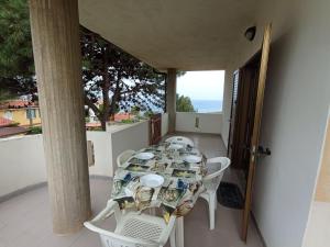 a table and chairs on the balcony of a house at Appartamento Loiacono - Seaview appartaments in Ricadi
