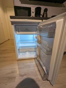um frigorífico vazio com a porta aberta numa cozinha em City-Apartment & Lift ,Tannen C6 em Wuppertal