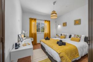 a bedroom with a large bed with a yellow blanket at Stunning Countryside Villa w Private Garden & Pool in Alte +47 photos