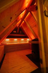 an attic room with a wooden floor and wooden ceilings at Fließ Paradies mit Blockbohlensauna in Leipe