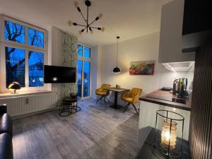 Il comprend une cuisine et un salon avec une table et des chaises. dans l'établissement Modernes Wohnstudio mit Balkon im Herzen von Bad Rothenfelde, à Bad Rothenfelde