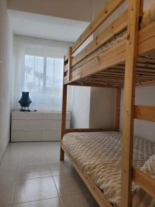 a bedroom with two bunk beds and a window at Torrenostra PLATJA in Torrenostra