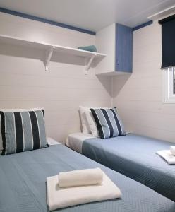 2 Betten in einem weiß-blauen Zimmer in der Unterkunft Casinhas dos Valados in Bolhos