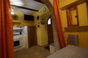 una cocina con paredes amarillas y un arco en Casetta del Rione, en Rocca di Mezzo