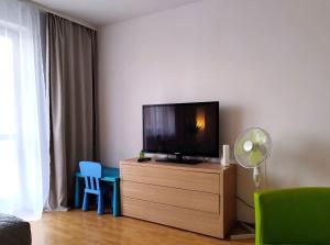 a living room with a flat screen tv on a dresser at GreenApartament in Krakow