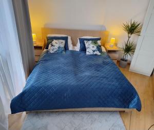 a bedroom with a blue bed with blue sheets and pillows at GreenApartament in Krakow