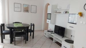 a dining room with a table and a television at Apartments Ines in Medulin