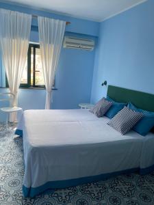 a blue bedroom with a large bed with blue walls at Case Borgo vacanze Bouganville in Letojanni