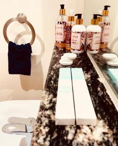 a bathroom counter with bottles of essential oils and a sink at Deluxe Flat in Muscat