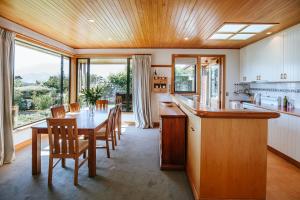 a kitchen with a long wooden table and chairs at Bullock Creek Chalet - Sleeps 8 - Lake & Mountain Views - Private & Secluded in Wanaka