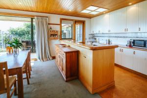 ワナカにあるBullock Creek Chalet - Sleeps 8 - Lake & Mountain Views - Private & Secludedの大きなキッチン(テーブル付)、大きな窓が備わります。 +12枚の写真