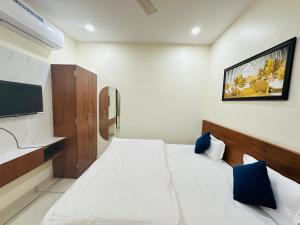 a bedroom with a bed and a tv on the wall at Vrindavan Hotel And Restaurant in Sālūmbar