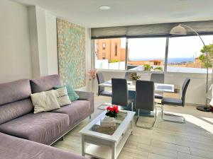 un soggiorno con un divano viola e un tavolo di El Mar House & Private Heated Pool ad Adeje