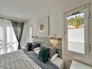 una camera da letto con un letto con cuscini verdi e una finestra di El Mar House & Private Heated Pool ad Adeje Altre 38 foto