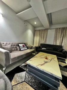 - un salon avec un canapé et une table dans l'établissement Essence Homes, à Islamabad