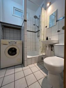 een badkamer met een toilet, een wastafel en een wasmachine bij Gdynia Śródmieście Necla Apartament in Gdynia