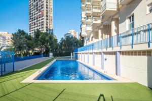 ein Swimmingpool an der Seite eines Gebäudes in der Unterkunft Tower San Remo 9-E Apartment Levante Beach in Benidorm