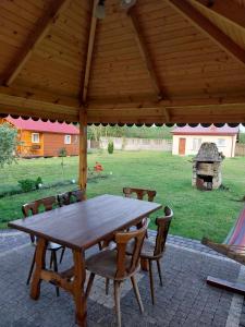 a wooden table and chairs under a wooden pavilion at Noclegi u Lucyny in Chęciny
