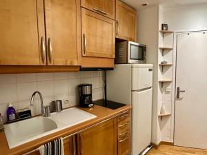 a kitchen with wooden cabinets and a white refrigerator at Superbe appartement hyper centre de Paris in Paris