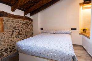 ein Schlafzimmer mit einem Bett in einer Steinmauer in der Unterkunft Niu de Queralt in Vic