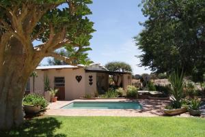a house with a swimming pool in a yard at Orpheus Inn & Glamping in Kaneb Pos
