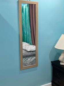 un espejo en una pared azul junto a una cama en SanAndros Airbnb en Marsh Harbour